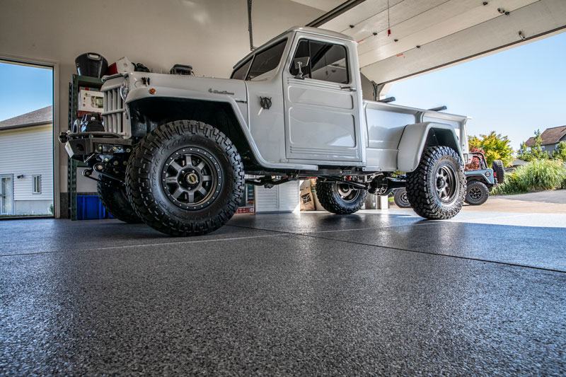 Full-flake garage floor with a lifted Jeep and the door open